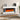 Freestanding electric fireplace with white mantel and dark inset, showing orange flame effect.