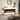 Freestanding electric fireplace with white mantel and dark frame, orange flames visible behind logs.
