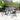Square outdoor dining table with textured glass top and black metal base