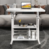 White overbed table with two-tier shelf and caster wheels, holding a laptop and books
