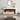 Freestanding electric fireplace with white mantel and dark sides, orange flame burning in insert.