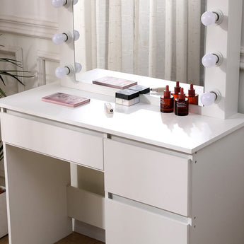 White vanity table with lighted mirror bulbs, tabletop accessories and storage drawers