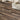 Wood-grain PVC floor planks on self-adhesive tiles, brown and tan staggered layout