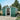 Dark green metal garden storage shed with sliding door open and interior contents visible