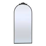 Black arched metal-framed standing mirror with decorative top