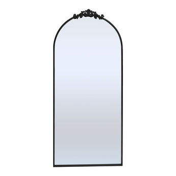 Black arched metal-framed standing mirror with decorative top