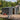 Dark gray metal garden tool storage shed with sliding roof vents and side door