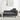 Grey chaise lounge with tufted back cushion and round wooden tray table beside