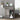 Bathroom storage cabinet with open lower door showing bottles and folded towels inside