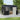 Anthracite metal storage shed with open door, window panels, and interior shelving view