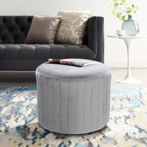 Light gray round velvet ottoman pouf, vertical stitched sides, flat round lid