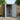 Grey wood-grain metal garden storage shed with doors open and diagonal brace panel
