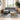 Grey chenille L-shaped sofa with chaise and rivet-studded arms, cup-holder style
