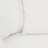 White corduroy upholstered cushion with ribbed texture and stitched seams