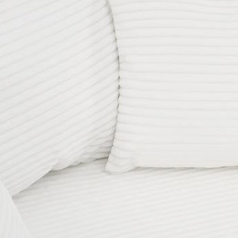 White corduroy upholstered cushion with ribbed texture and stitched seams