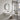 Wall-mounted arched bathroom mirror with dark frame and reflective glass panel