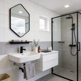 Black wall-mounted bathroom mirror with slim aluminium frame, octagonal shape