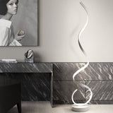 Minimalist LED spiral floor lamp with glowing white curved tube and round white base.