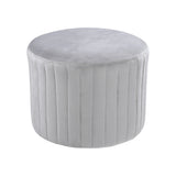 Light gray round velvet ottoman pouf with vertical channel seams and smooth round top