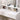 White vanity top with cosmetics bottles on the illuminated mirror dressing table