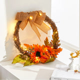Decorative wreath with orange flowers, pinecones, berries, burlap ribbon and LED lights