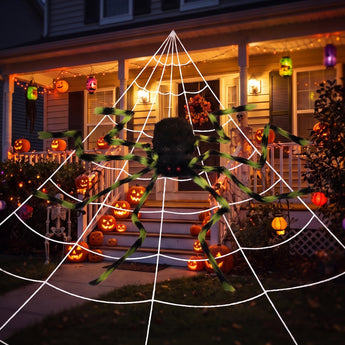 Giant Halloween spider decoration with black body and green-striped legs on white web