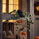 Giant Halloween spider decoration with black body and green-striped legs on a porch beam
