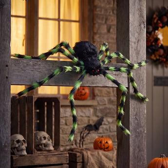 Giant Halloween spider decoration with black body and green-striped legs on a porch beam