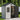 Gray outdoor storage shed with open dark door and visible storage interior