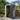 Plastic storage shed with open lockable door showing interior shelves and tools