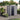 Grey plastic garden storage shed with front doors, one open, pent roof design