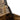 Flip-top lid hinge and support bar on dark brown wooden storage bench.
