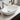 White ceramic vessel sink with round drain opening and chrome faucet