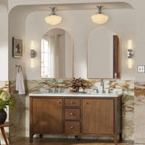 Arch-shaped gold-framed wall mirror above a vanity with built-in lights