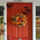 Halloween door wreath with orange, black, and gold leaves, pinecones, and pumpkins