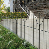 Dark metal garden fence with arched sections and vertical bars along a walkway