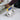Corner trowel used on a wall edge with blue/yellow grip and metal blade