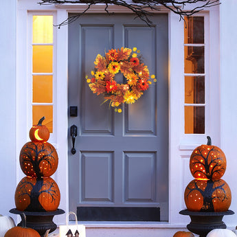 Halloween autumn wreath with orange and yellow flowers and warm glowing lights