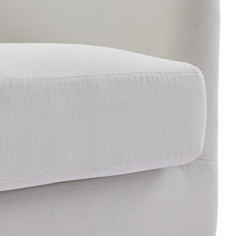 Cream fabric armchair armrest with rounded edge and upholstered seat.