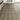 Wood-effect vinyl floor tile in medium gray with herringbone woodgrain texture