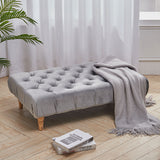 Rectangular velvet footstool with tufted top and gray throw blanket