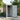 Grey metal garden storage shed with door open showing wall-mounted tool hooks