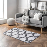 Grey and white geometric shag area rug with repeating quatrefoil pattern