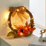 Decorative wreath with orange flowers, berries, pinecones, burlap bow, glowing LED lights
