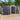 Steel garden storage shed with gable roof, double doors open to reveal interior storage.
