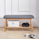 Bamboo shoe bench with gray cushioned seat, lower shelf with basket and shoes