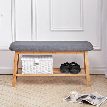 Bamboo shoe bench with gray cushioned seat, lower shelf with basket and shoes