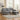 Grey chenille L-shaped sofa with cup-holder arm, chaise section, and rivet accents