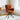 Orange high-back accent chair with curved arms and black swivel base