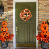 Halloween wreath with autumn leaves and pumpkin ornaments, displayed on front door